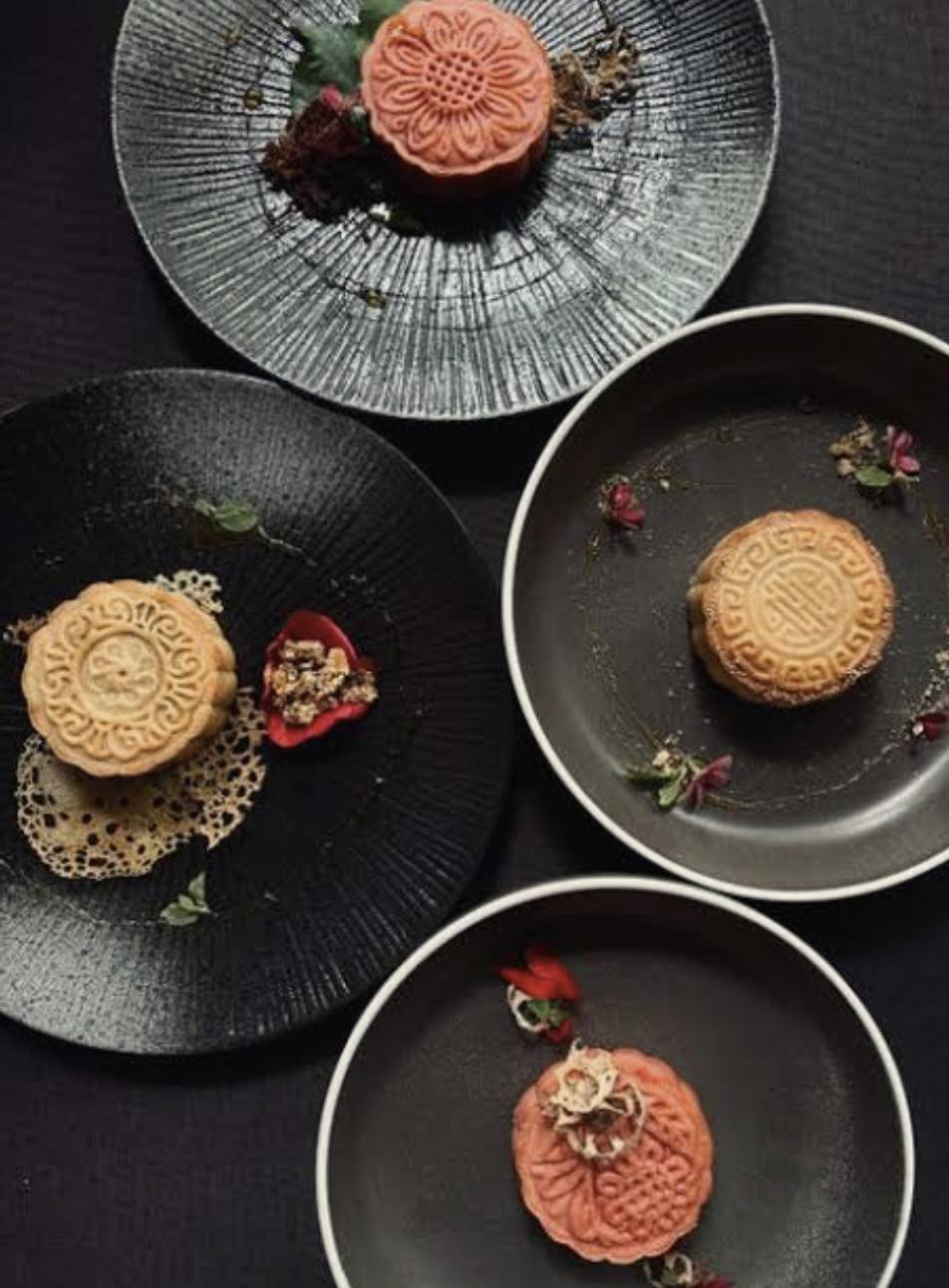 Hand-pressed mooncakes on dark ceramic plates